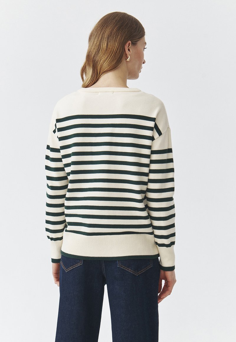 Sweter w paski w kolorze kremowym i ciemnozielonym, z prążkowanym dołem i mankietami, o luźnym kroju i opadających ramionach.
