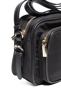 Borsa a tracolla nera in nylon con cerniere dorate, due scomparti e tracolla regolabile. Texture liscia e design minimalista.