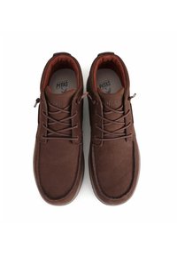 Zapatos de cuero marrón con un acabado texturizado, puntera redondeada y forro interior en contraste, con cordones tradicionales y suela de goma.