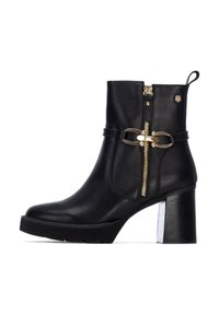 Botín negro de cuero hasta el tobillo con un zipper dorado, hebilla decorativa y un tacón robusto con base texturizada.
