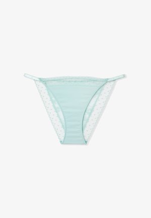 Jasnozielone figi typu thong z miękkiej, gładkiej tkaniny i koronkową lamówką ozdobioną wzorem w groszki na krawędziach. Cienkie paski umożliwiające regulację dopasowania.