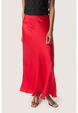 Rød satin maxi-nederdel med en glat tekstur og en svajende silhuet, der har et enkelt, uprydet design. Sorte sko er inkluderet.