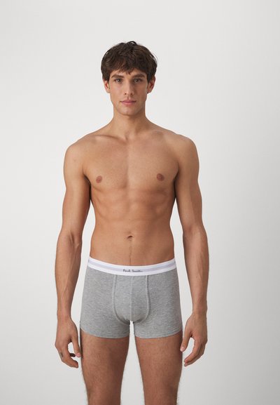 Boxer-briefs en coton gris avec une ceinture élastique blanche arborant le logo "Paul Smith". Texture lisse, design ajusté. Le modèle se tient de face.