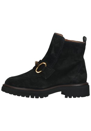 Black suede ankle boot with a rounded toe, gold-tone buckle accent, and textured rubber sole featuring deep treads for grip.