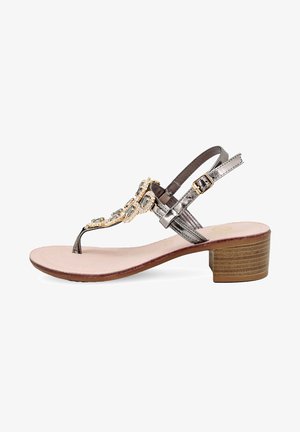 Sandal di metallo grigio con tacco, dotata di cinturino alla caviglia, decorata con pietre decorative e zeppa texturizzata. Soletta in morbido beige.