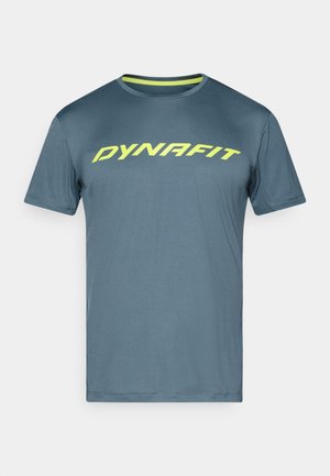 Camiseta deportiva de manga corta azul con el logo en neón amarillo "DYNAFIT" en el pecho, cuello redondo y ribete interior del cuello en amarillo de contraste.