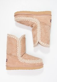Beige semsket ankle boots med en myk tekstur, som har dekorativ søm og en tykk gummisåle. Fôret med luksuriøst materiale for varme.