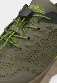 Nærbillede af olivengrøn vandresko med åndbart mesh, neongrønne snørebånd, hurtigtlåsesystem og beige gummisål.