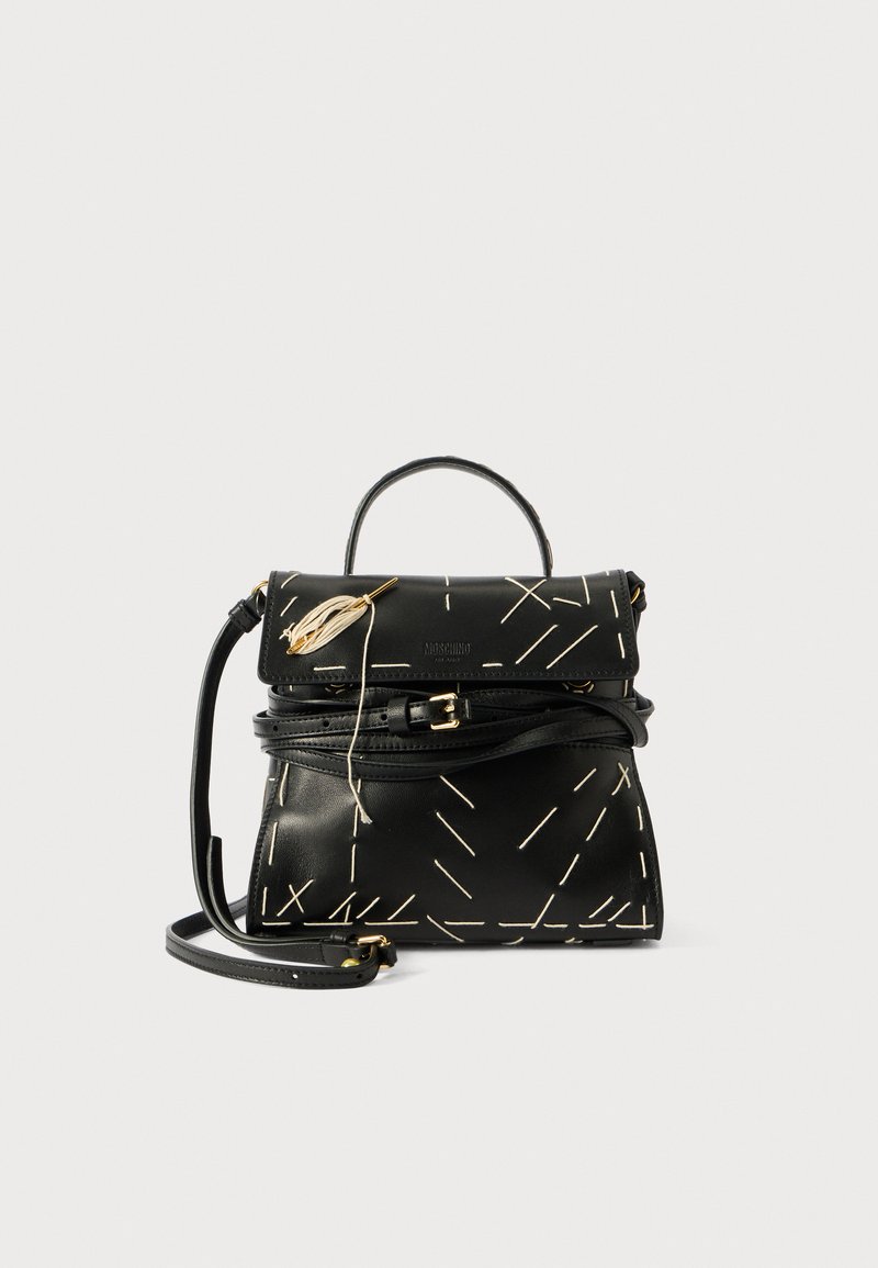 Black leather handbag with geometric white stitching, a top handle, and a detachable shoulder strap. Features gold accents and a zip closure.
