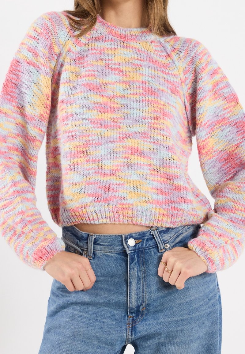 Pull en tricot à motif multicolore dans les tons de rose, violet et jaune, avec un ourlet côtelé et des manches larges.