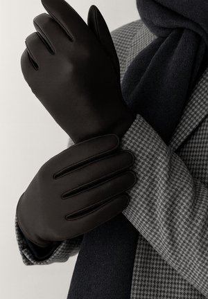 Black leather gloves with five finger design, smooth texture, and stitched detailing. Worn over a patterned gray coat and navy scarf.