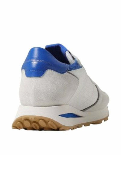 Scarpa sportiva bianca e blu con una tomaia liscia, tallone texturizzato e suola in gomma con motivi a cerchio per una migliore aderenza.