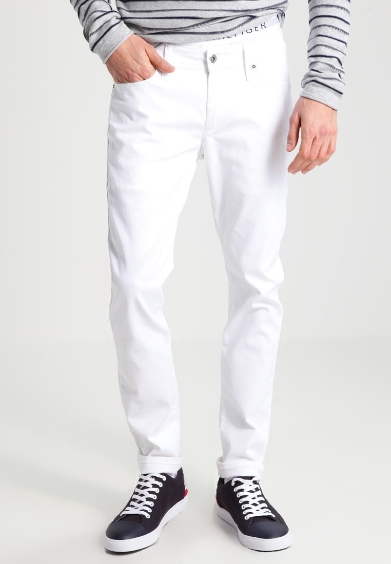 Vita bomullsjeans med smal passform, med femficksdesign och dragkedja. Matchas med mörka sneakers och en grårandig långärmad tröja.