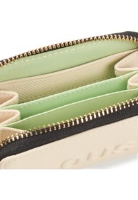 Cream-colored wallet with gold zipper, featuring green fabric compartments and embossed logo detail, displaying a textured leather finish.