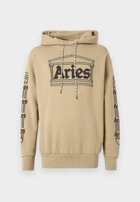 Kapuć sweatshirt u bež pamuku s crnim grafičkim tiskom "Aries" i arhitektonskim detaljima. Ima vezice i rebraste manžete.