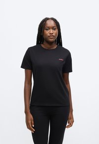 Fekete pamut póló rövid ujjakkal, kerek nyakkivágással, a bal mellrészen kis piros "HUGO" logóval.