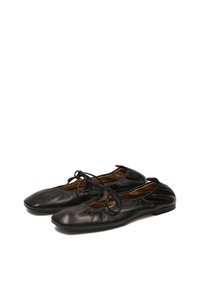 Black leather ballet flats with a stitched edge, rounded toe, and a bow accent on the upper. Soft texture with a simple design.