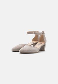 Décolleté in suede beige con punta affilata e cinturino alla caviglia. Presenta un tacco largo e una superficie liscia. Fibbia regolabile per una vestibilità ottimale.
