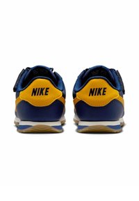 Baskets Nike bleu marine et jaune avec un dessus texturé, un col rembourré et une semelle en caoutchouc avec un motif triangulaire pour une meilleure adhérence.