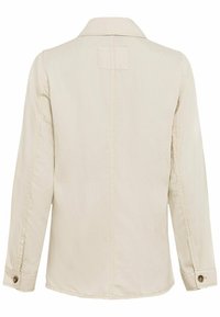 Beige jakke med krave, lange ærmer og knaplukning ved håndleddene, med en glat tekstur og minimalistisk design. Bagfra ses sømdetaljer.