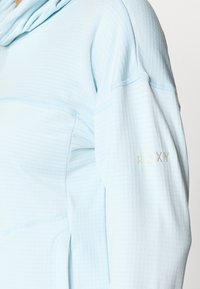 Svetlomodrá mikina s kapucňou vyrobená z textúrovaného materiálu s rebrovaným vzorom. Obsahuje logo na rukáve a kontrastné švy.