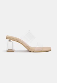 Klare Absatzsandalen mit zwei transparenten Riemen. Mit einem quadratischen Zehenbereich und einem transparenten Blockabsatz. Die Farbe ist Nude mit einer glatten Textur.