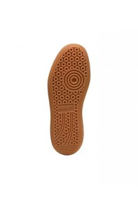 Suela de zapato de goma con un patrón de panal y diseños circulares. Color marrón claro con textura elevada y logotipo de "Puma".