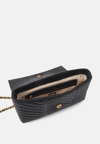 Sort, quiltet skuldertaske med gylden kæde-rem, beige indvendig foret, og indvendig lynlåslomme, åbnet klap med gylden knappelås.