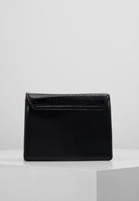 Borsa in pelle nera a forma rettangolare, con un design lucido a motivo coccodrillo sulla pattina e bordi puliti. Dettaglio hardware minimale.