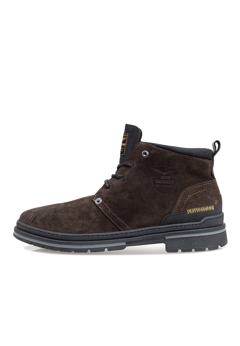 Bottines en suède marron avec des accents noirs, bout rond et semelle en caoutchouc durable. Elles sont dotées de lacets, d'œillets et de détails de couture contrastants.