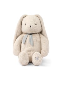 Bunny de peluche suave en color beige, con orejas largas, ojos negros, un lazo de cinta a cuadros y un pequeño parche de cara de oso en su pie.