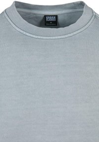 Felpa azzurro chiaro con colletto a girocollo a costine e tessuto testurizzato. Presenta l'etichetta Urban Classics ed è realizzata in morbido tessuto di cotone misto.