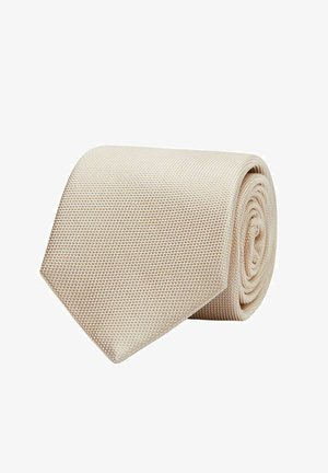 Beige tekstiili siduri, rullitud terava otsaga. Kude sisaldab kudumise mustrit, mis annab peene, kuid eristuva välimuse.