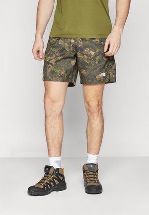 T-shirt i olivengrøn, camouflage-shorts med et struktureret mønster i grøn og brun, og sorte vandrestøvler med orange accenter og mesh-paneler.