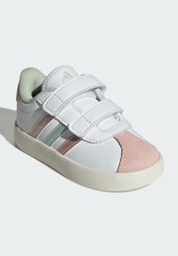 Sneaker bianco con strappi in velcro, caratterizzato da accenti in suede rosa e verde, suola in gomma testurizzata e finitura in pelle senza cuciture.