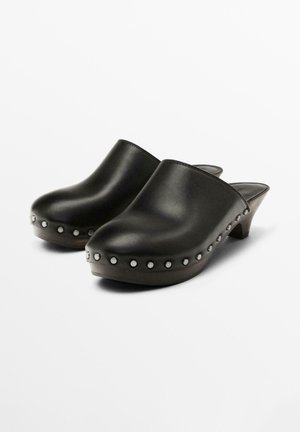 Black leather clogs with a smooth finish, featuring silver studs along the side, and a low wooden heel. Closed back design.