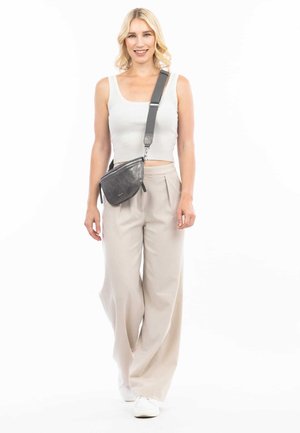 Ensemble composé de deux pièces incluant un haut blanc côtelé court et un pantalon large taille haute beige clair, associé à un petit sac en bandoulière gris.