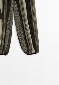Long sheer pants with vertical stripes in black, olive green, and beige, featuring elastic cuffs at the ankles.