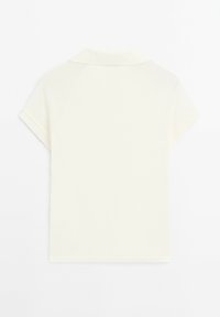 Polo tričko s krátkým rukávem a límečkem v krémové barvě. Vyrobeno z hladké tkaniny s jednoduchým designem a jemnými švy na spoji.