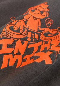 Szary materiał z pomarańczowym graficznym wzorem przedstawiającym DJ-a przy gramofonach, z napisem "IN THZ MIX" w wyrazistym, stylizowanym kroju pisma.