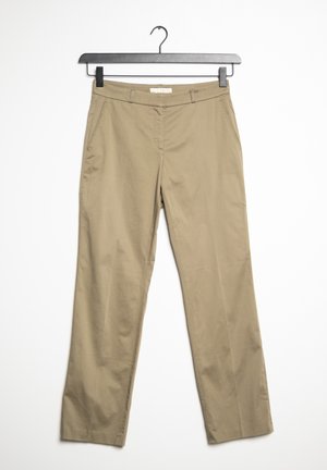 Beige Hosen mit geradem Bein und Fronttaschen, hängend an einem schwarzen Bügel vor weißem Hintergrund.