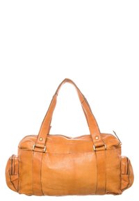 Sac à main en cuir marron avec doubles poignées, compartiment principal zippé, poches latérales et détails de couture, présentant une texture lisse.