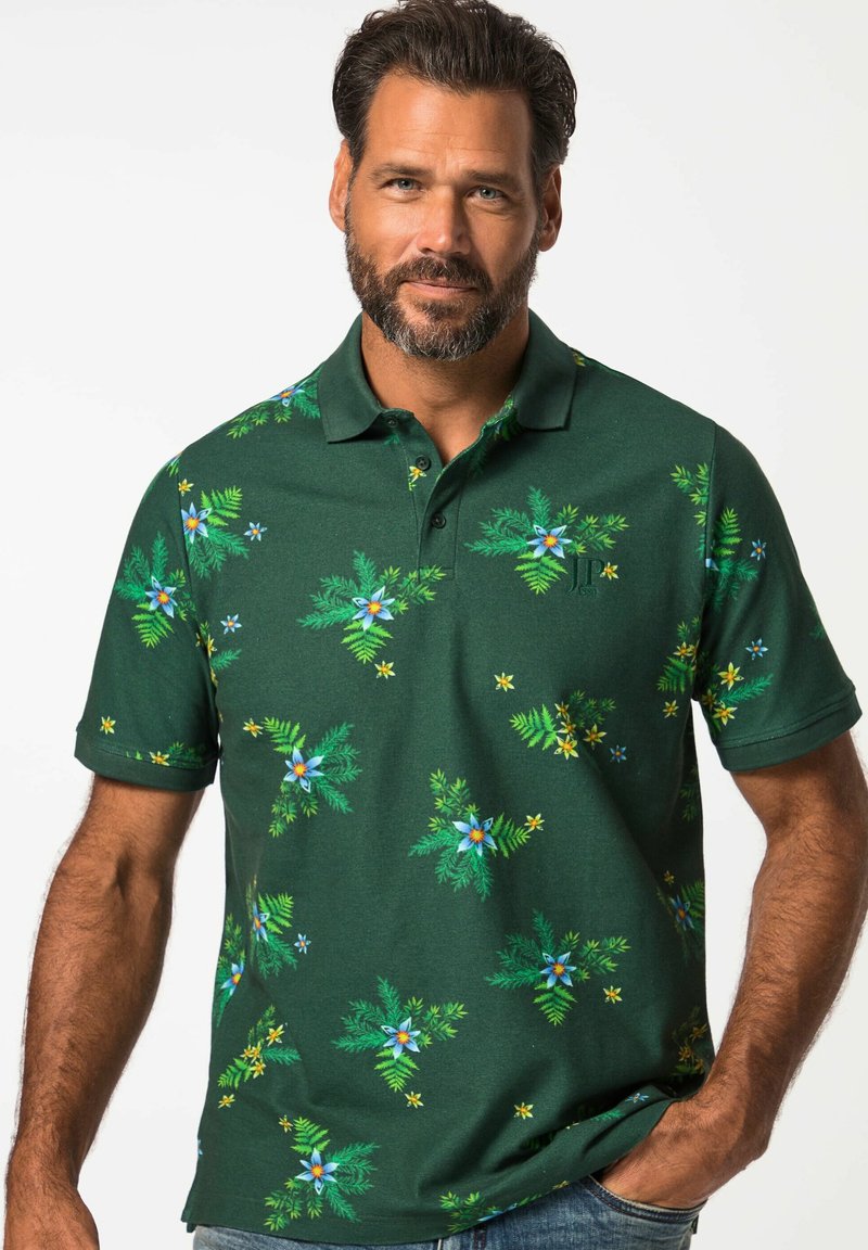 Zelené polo tričko s květinovým vzorem, na němž jsou modré a žluté květiny, krátké rukávy a límec. Materiál vypadá měkce a strukturovaně.