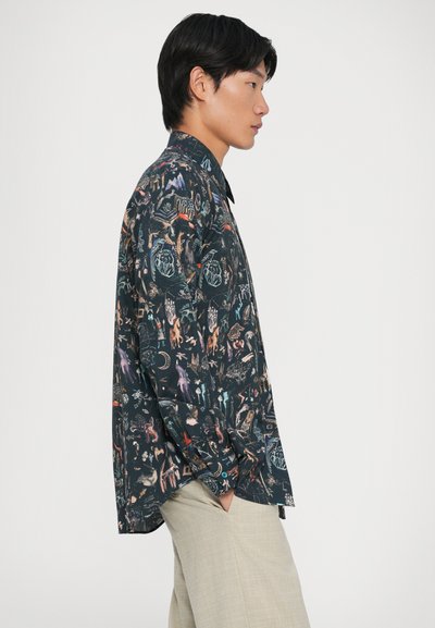 Camicetta a maniche corte in tessuto scuro con motivi colorati e intricati di animali e piante; vestibilità rilassata e design con colletto a punte.