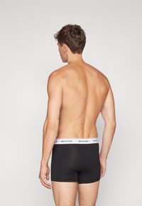Boxerii negri cu un elastic alb inscripționat "SELECTED". Material neted, design ajustat, priviți din spate.