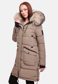 Cappotto imbottito trapuntato beige con cappuccio foderato in pelliccia, due tasche anteriori con zip e polsini elasticizzati. Presenta dettagli neri e un design lungo fino al ginocchio.