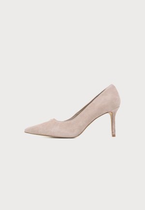 Une chaussure à talon haut en daim beige, avec un bout pointu et un talon fin sur un fond clair uni.