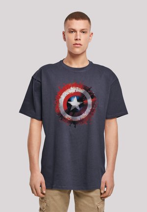 Tengerészkék pamut póló, amelyen egy kopott Kapitány Amerika pajzs grafika látható piros, fehér és kék színekben, festékspricc részletekkel.