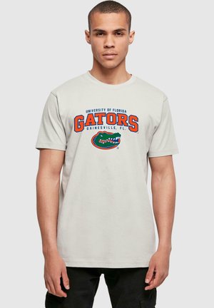 Hellgraues Baumwoll-T-Shirt mit dem Text "University of Florida Gators Gainesville, FL" in Blau und Orange, darunter eine Gator-Grafik.