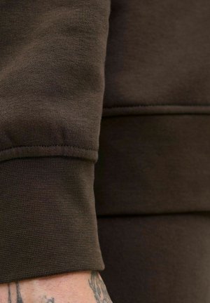 Bruine katoen sweatshirtstof met ribbelmanchetten en een gestructureerde afwerking. Zichtbare naaddetails en een close-up van het mouwgebied.